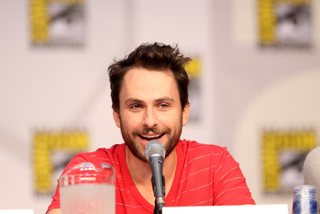 Charlie Day playing a guitar with a smile, an It's Always Sunny in Philadelphia logo in the background.