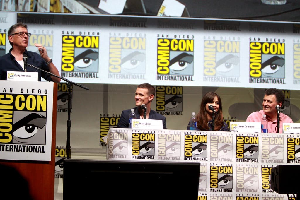 Steven Moffat smiles during an interview, wearing a dark jacket and light shirt.