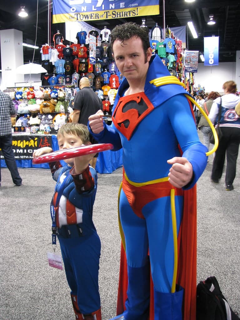 Superboy-Prime screaming "HEY YOU, GET ME OUTTA HERE!" while surrounded by various iterations of Superman throughout DC history.