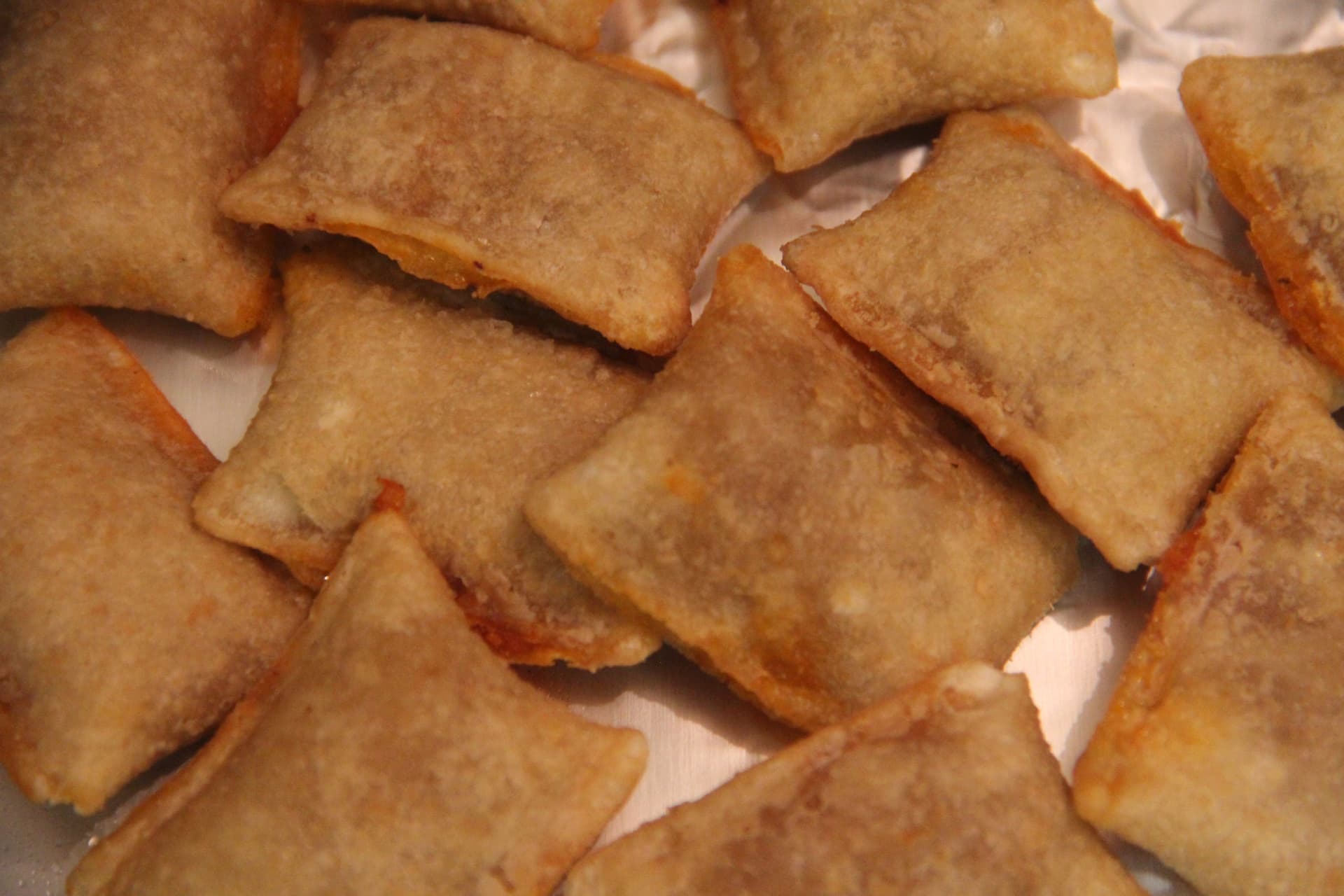 Assortment of Totino's Blasted Pizza Rolls bags with new flavors like Garlic Parm, Zesty Limón, and Chicken Bacon Ranch
